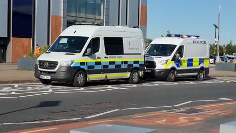 Travellers-passing-British-border-force-police-van-parked-outside-John-Lennon-airport,-Liverpool-during-asylum-seeking-crisis-control
