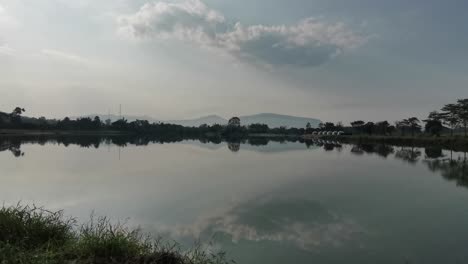Der-Kristallklare-See-Verfügt-über-Vollkommen-Ruhiges-Wasser,-Das-Spiegelbilder-Der-Umliegenden-Landschaft-In-Thailand-Erzeugt