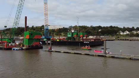 Construction-platform-building-a-new-bridge-in-Waterford-City-on-a-summer-morning,with-workmen-in-a-boat