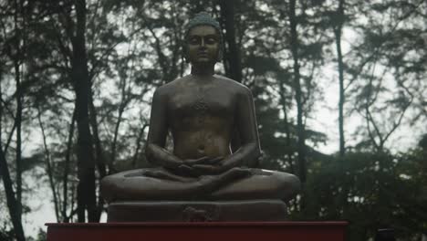 Close-Shot-Of-Famous-Buddha-Statue-Placed-Out-In-Front-Of-High-rise-Trees