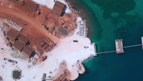 Aerial-top-down-shot-of-construction-site-with-industrial-equipment-during-sunny-day-in-Pedernales,-Dominican-Republic---Port-Cabo-Rojo