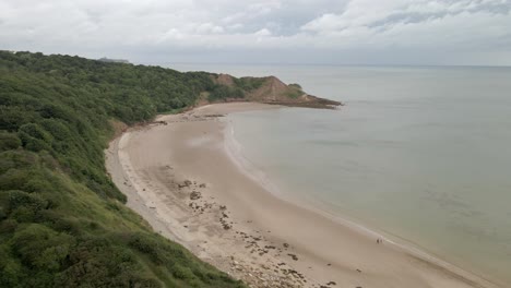 Aerial-drone-shot-over-Cayton-bay,-Scarborough,-North-Yorkshire-on-a-cloudy-day