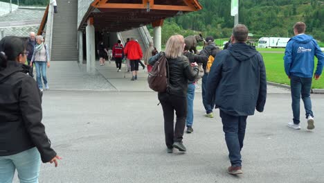 People-exit-bus-and-walking-towards-entrance-of-Norwegian-glacier-museum-in-Fjaerland-Sogn