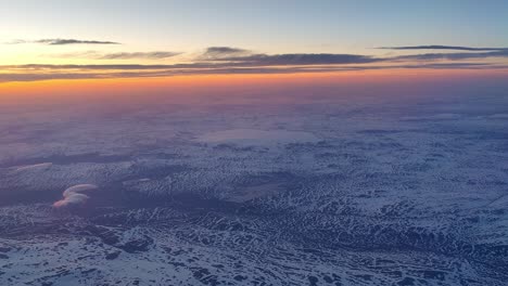 Hardangerjokulen-glacier-surrounded-by-mountain-landscape-seen-from-high-altitude-descending-airplane-during-sunset