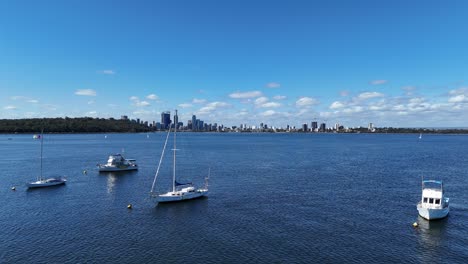 Cinematic-drone-flight-past-sailing-yacht-masts-with-Perth-city-skyline-in-the-background