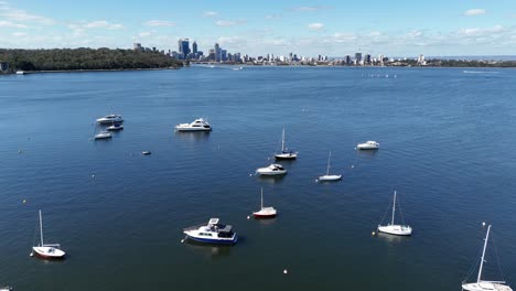 Cinematic-aerial-view-of-Perth-city-skyline-in-Western-Australia-with-sailing-yachts-moored-in-Matilda-Bay-marina