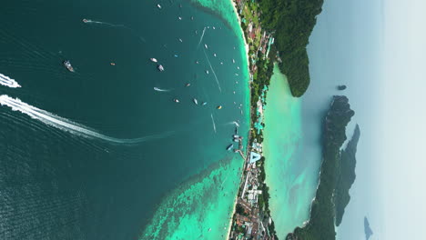 Vertical-aerial-view-of-boats-off-touristy-Tonsai-Beach,-Koh-Phi-Phi,-Thailand