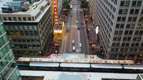 Aerial-view-backwards-over-the-L-train-stopped-at-North-State-Street,-in-Chicago