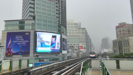 Asoke-BTS-Bahnhof-Im-Monsunregen-Mit-Einem-Ankommenden-Zug