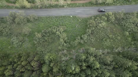 Drone-Siguiendo-Un-Coche-Por-El-Lado-Del-Bosque