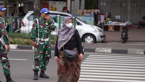 Berufstätige-Frauen-überqueren-Die-Straße,-Um-Zum-Bahnhof-Senen-Zu-Gelangen,-Und-Sicherheitsbeamte-Sichern-Die-Aktivitäten-In-Jakarta