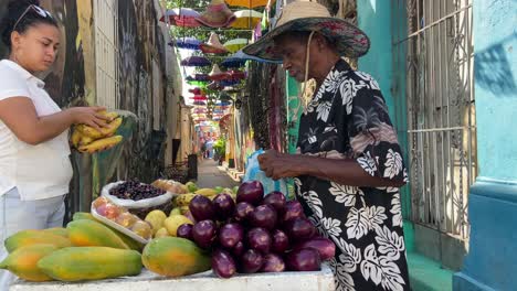 Woman-buying-bananas-to-street-Colombian-fruit-vendor-in-Cartagena-de-Indias