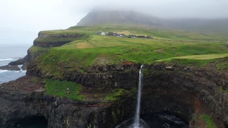 Fairytale-Mulafossur-waterfall-with-foggy-Gasadalur-village-in-background