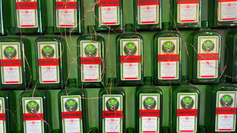 Jägermeister-Deutsche-Digestif-Alkoholgrünflaschen-An-Einer-Wand,-Alkoholisches-Getränk,-4K-Aufnahme