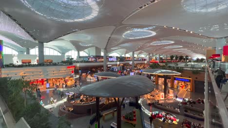 Fantastischer-Blick-Von-Der-Business-Lounge-Der-Turkish-Airlines-Auf-Den-Internationalen-Flughafen-In-Istanbul,-Menschen,-Die-Durch-Geschäfte-Und-Restaurants-In-Der-Türkei-Laufen,-Geschäftiger-Flughafen-Mit-Luxusgeschäften,-4K-Aufnahme