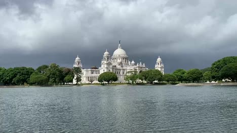 Shot-of-a-pristine-lake-in-front-of-Victoria-Memorial-surrounded-by-green-vegetation-in-Kolkata,-West-Bengal,-India-on-a-rainy-day