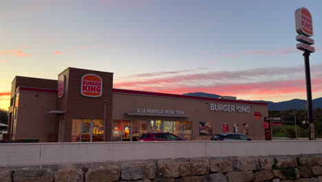 Hermosa-Puesta-De-Sol-Rosa-Anaranjada-En-El-Restaurante-Burger-King-En-Estepona,-España,-Increíble-Puesta-De-Sol-En-Auto-King-Drive,-Panorámica-De-4k-Hacia-La-Derecha