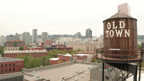 Aufsteigende-Luftaufnahme-Des-Wassertanks-Der-Altstadt-Von-Portland,-Der-Das-Stadtzentrum-Freigibt