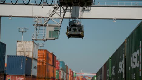 Operating-cargo-crane-moves-forward-over-ship-containers-at-international-port