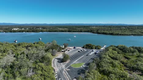 Aerial-drone-shot-orbiting-Beachmere-Boat-Ramps-on-Caboolture-River,-Boats-in-river-opening-to-the-Ocean-Moreton-Bay