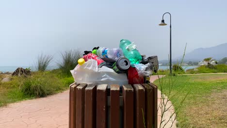 Überfüllter-Müllcontainer-Am-Strand,-Menschen,-Die-Keinen-Müll,-Plastik,-Flaschen-Und-Dosen-In-Marbella,-Spanien,-Recyceln,-4K-Aufnahme