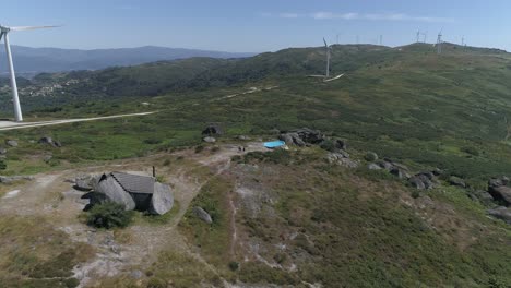 Luftaufnahme-Eines-Hauses-In-Den-Bergen-Mit-Windmühlen