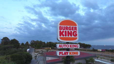 Aerial-view-of-Burger-King,-Auto-King-and-Play-King-sign-in-Estepona-Spain,-4K-shot