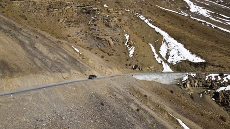 Drone-Fluyendo-Un-Automóvil-En-El-Valle-De-Spiti-Himachal-Pradesh-Conduciendo-Montañas-Himalaya-India-Paisaje