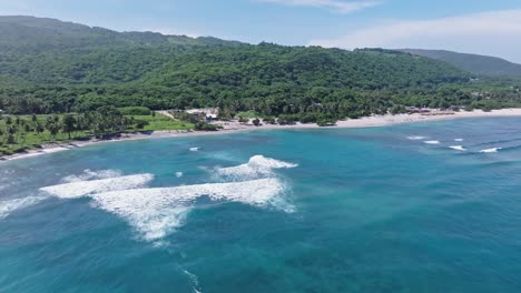 Waves-crashing-to-tropical-sand-beach-resort-in-El-Quemaito,-drone-forward