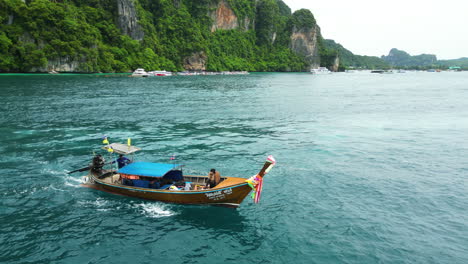 Couple-on-romantic-trip-on-longtail-boat-at-Koh-Phi-Phi-islands,-Thailand,-aerial-view