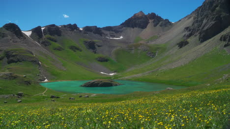 Aerial-cinematic-drone-Ice-Lake-Basin-Silverton-Island-Lake-aqua-blue-clear-water-alpine-tundra-stunning-mountain-range-yellow-wildflowers-mid-summer-daytime-blue-beautiful-slow-pan-to-the-left-motion