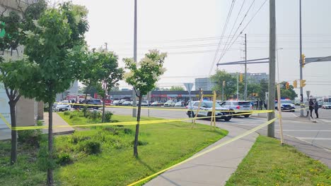 Vehículos-Policiales-Fuera-De-La-Escena-Del-Crimen,-Con-Luces-De-Sirena-Encendidas,-En-Un-Día-Soleado