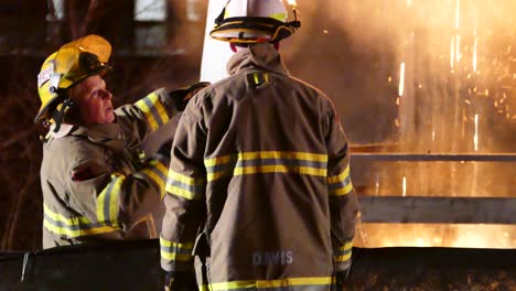 Feuerwehrleute-Versuchen-Nachts,-Einen-Brennenden-Brand-In-Einem-Backsteingebäude-Zu-Löschen,-Aus-Dem-Rauch-Austritt