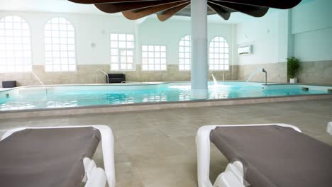 Slow-motion-dolly-shot-of-a-Thalasso-pool-and-loungers-in-a-private-spa