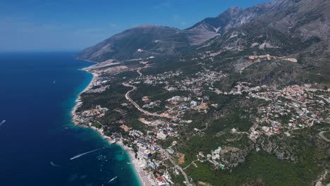 Coast-of-Albanian-riviera-with-touristic-villages-on-mountain-slopes-overlooking-blue-turquoise-Ionian-sea,-summer-vacation-destination
