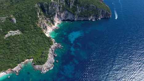 Amazing-coast-of-Ionian-sea-in-Albania,-blue-turquoise-sea-water,-cliffs-and-green-vegetation,-panoramic-Mediterranean-destination-for-summer-vacation