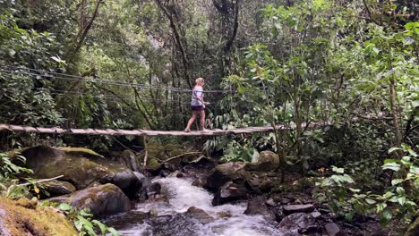 Woman-bravely-crossing-a-wooden-suspension-bridge-in-the-Amazon-jungle