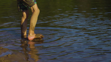 Little-Boy-Walking-In-The-Shallow-Water-Of-A-Lake---close-up