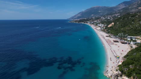 Large-beach-of-Dhermi-in-Albania,-white-sand-and-blue-turquoise-sea-water-on-summer-vacation-destination,-attractive-tourist-seaside