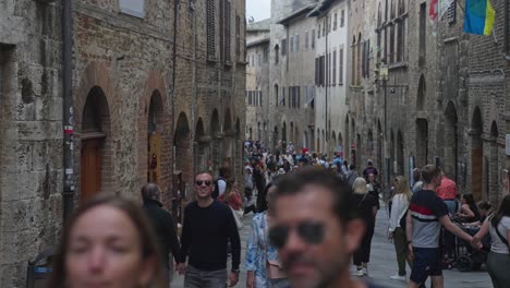 Überfüllte-Straße-In-Der-Stadt-San-Gimignano-Mit-Touristen,-Cafés-Und-Restaurants-Zwischen-Den-Historischen-Gebäuden-In-Italien