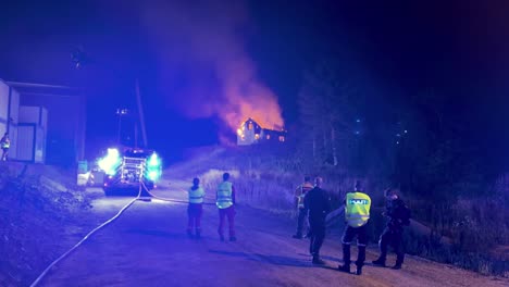 Ersthelfer,-Feuerwehrleute-Und-Polizisten-Untersuchen-Ein-Brennendes-Haus,-Nachdem-Sie-Zu-Spät-Gekommen-Sind