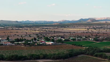 Agricultural-field-on-the-outskirts-of-aguascalientes-mexico,-mountainous-backdrop,-aerial-trucking-pan