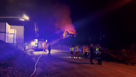 Feuerwehrleute-Sprühen-Wasser-Auf-Nahe-Gelegenes-Gebäude,-Nachdem-Das-Haus-Bis-Auf-Die-Grundmauern-Niedergebrannt-Ist