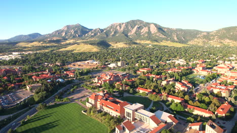 Drone-flying-the-University-of-Colorado-Boulder-,-with-the-flatirons-and-the-town-of-Boulder-in-the-background