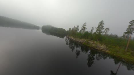 Early-autumn-morning-FPV-drone-flight-over-a-misty-nordic-lake-in-Sweden