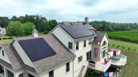 Junge-Männer-Installieren-Sonnenkollektoren-Auf-Einem-Großen-Amerikanischen-Haus