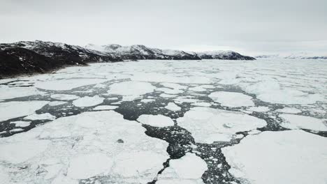 Melting-glacier-pieces-floating-in-deep-ocean,-aerial-drone-view