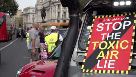 A-placard-on-a-jeep-windscreen-reads,-“Stop-the-toxic-air-lie”-as-vehicles-and-people-gather-on-Whitehall-during-an-anti-Ultra-Low-Emission-Zone-protest