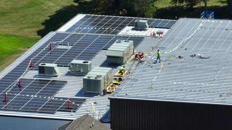 Männliche-Arbeiter-Auf-Dem-Dach-Eines-Industriegebäudes-Installieren-Sonnenkollektoren,-Um-Das-Unternehmen-Mit-Erneuerbarer-Energie-Zu-Versorgen