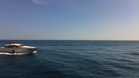 Aerial-view-of-luxury-yacht-driving-fast-in-sea,-sailing-in-Marbella-Spain,-beautiful-Mediterranian-sea,-jetset-elite-lifestyle,-copy-space,-background,-4K-drone-shot